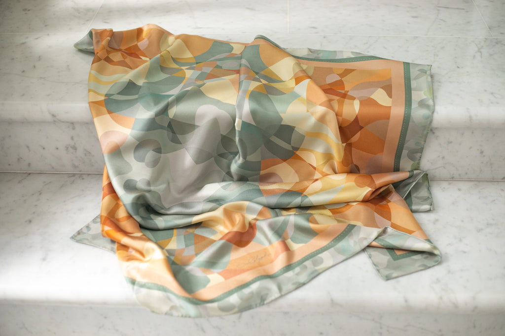 Harmony silk scarf by Glyph draped on marble, highlighting the soft texture, natural sheen and fluidity of the silk twill.
