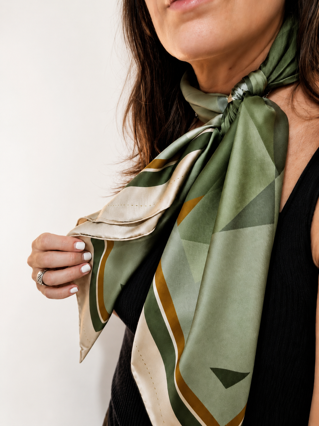 Silent Compass silk scarf by Glyph, styled around the neck, featuring layered green tones and geometric details inspired by inner direction and clarity.